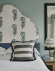 Christopher Farr Cloth Nomad Dark Indigo cushion styled in a classical blue bedroom interior, adding texture and pattern to a floral headboard. This setting captures a moment of calm and rest. Photography by Christopher Horwood.